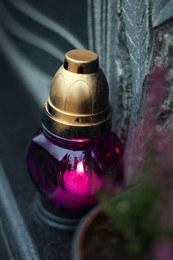 Photo of Grave light on granite tombstone at cemetery, closeup