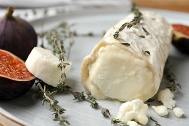 Photo of Delicious goat cheese with figs and thyme on plate, closeup