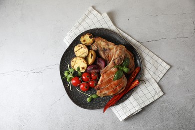 Delicious grilled meat and vegetables on light grey table, top view