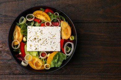 Photo of Bowl of tasty salad with leek and cheese on wooden table, top view. Space for text