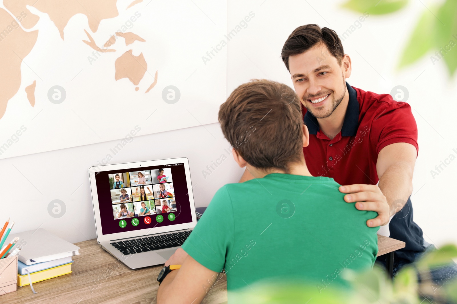 Image of Distance learning during quarantine and lockdown due to Covid-19 pandemic. Father helping his son with online school lesson