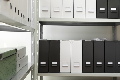 Photo of Folders with documents on shelves in archive