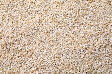 Photo of Raw barley groats as background, top view