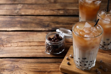 Tasty milk bubble tea on wooden table. Space for text