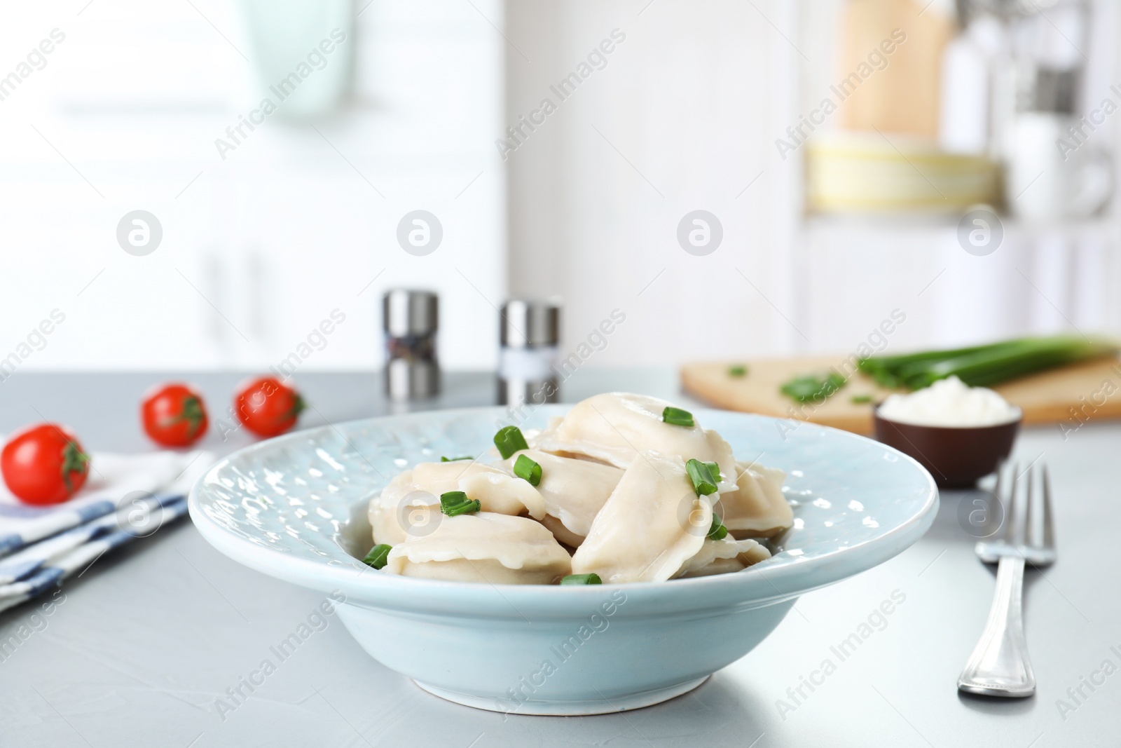 Photo of Plate of tasty dumplings served with green onion on table