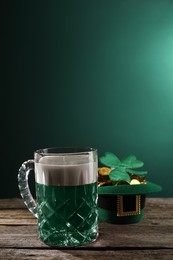 St. Patrick's day celebration. Green beer, leprechaun hat with gold and decorative clover leaf on wooden table. Space for text