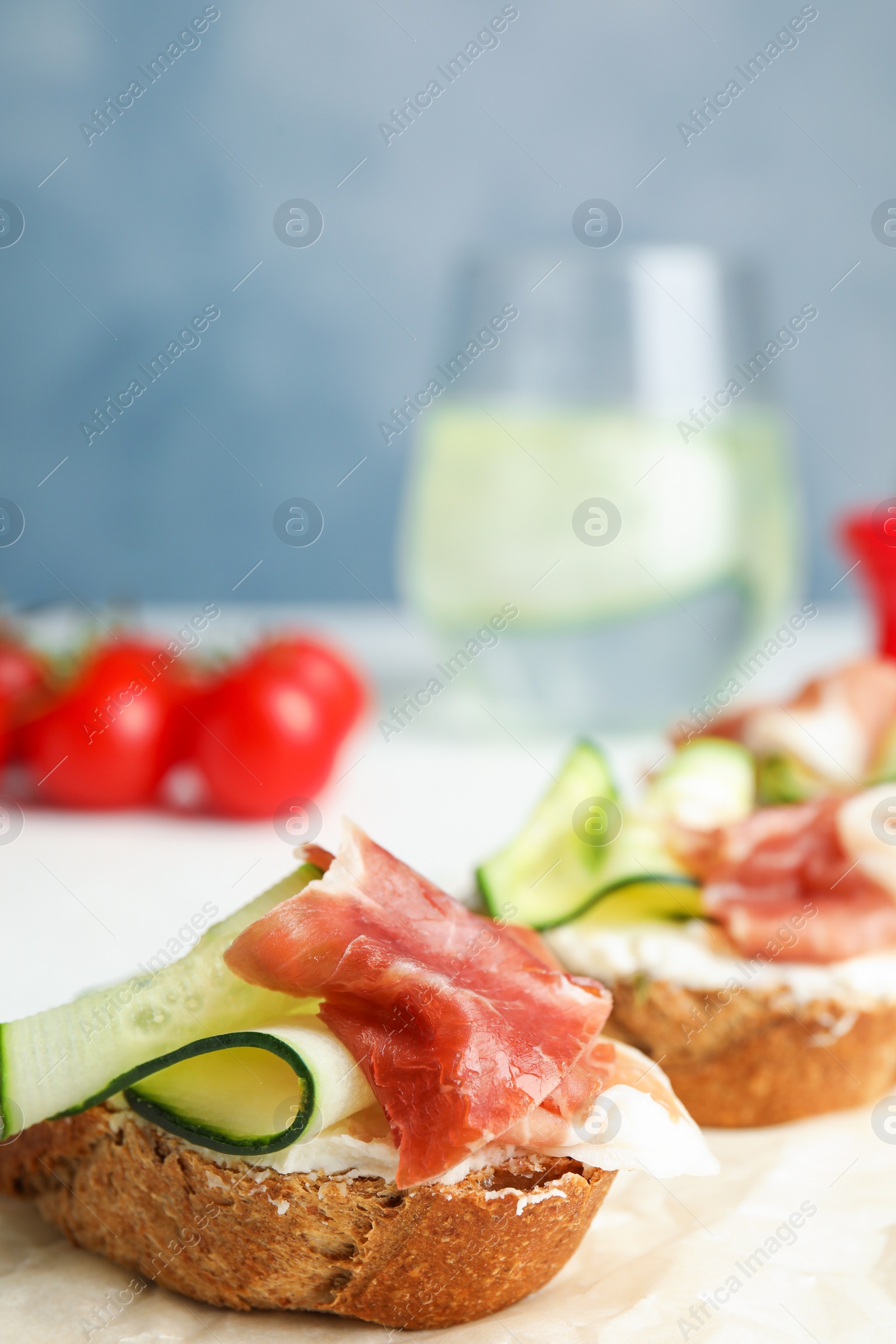 Photo of Tasty bruschettas with prosciutto served on table