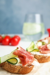 Photo of Tasty bruschettas with prosciutto served on table