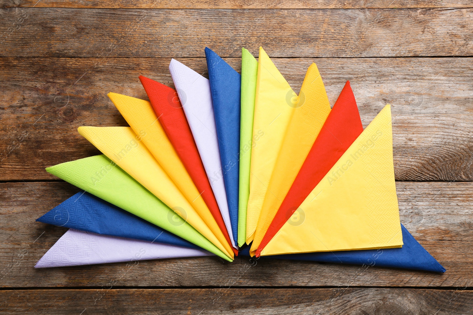 Photo of Colorful paper napkins on wooden background, top view