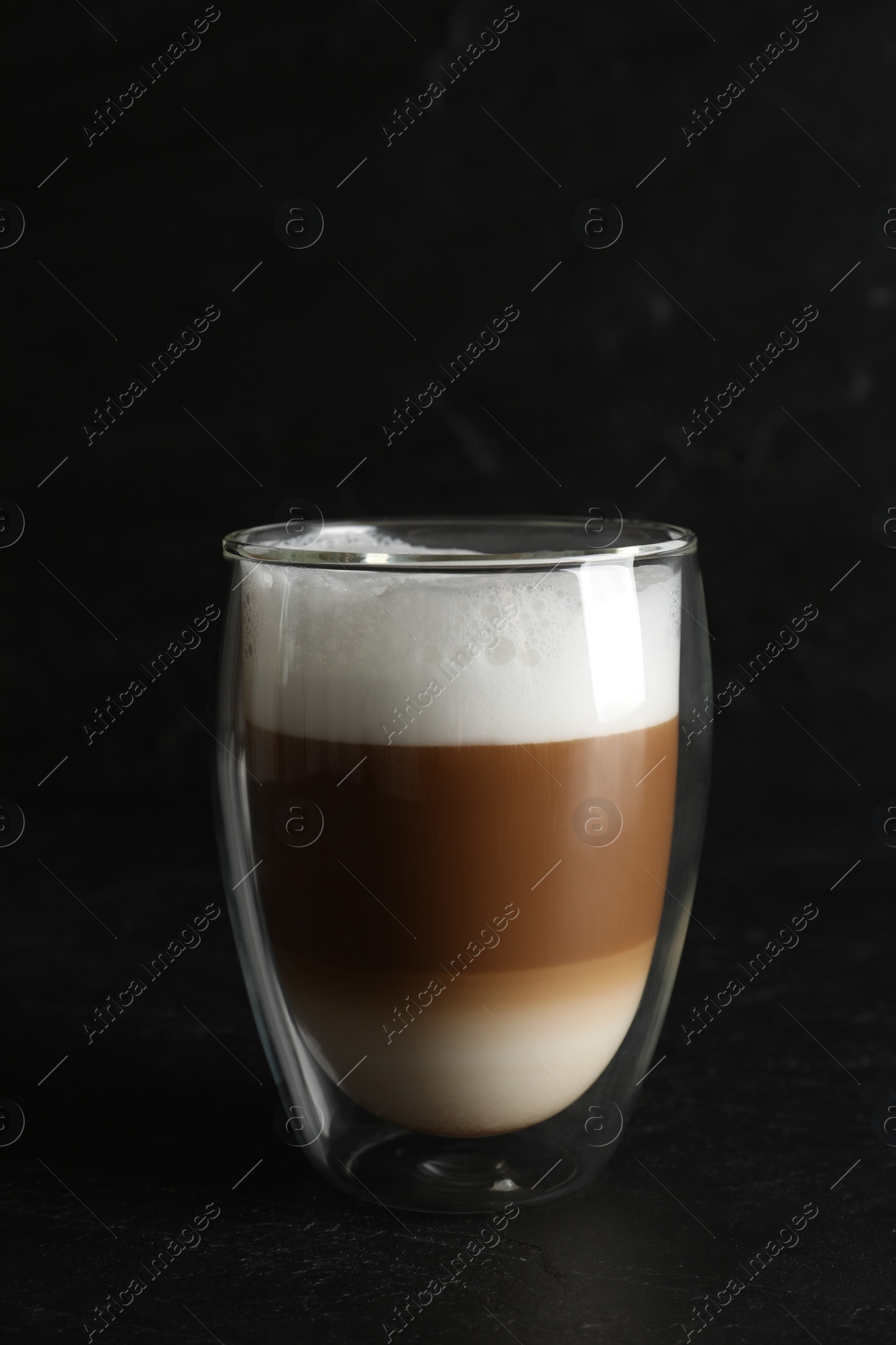 Photo of Hot coffee with milk in glass on black table