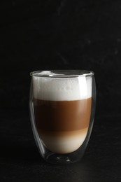 Hot coffee with milk in glass on black table