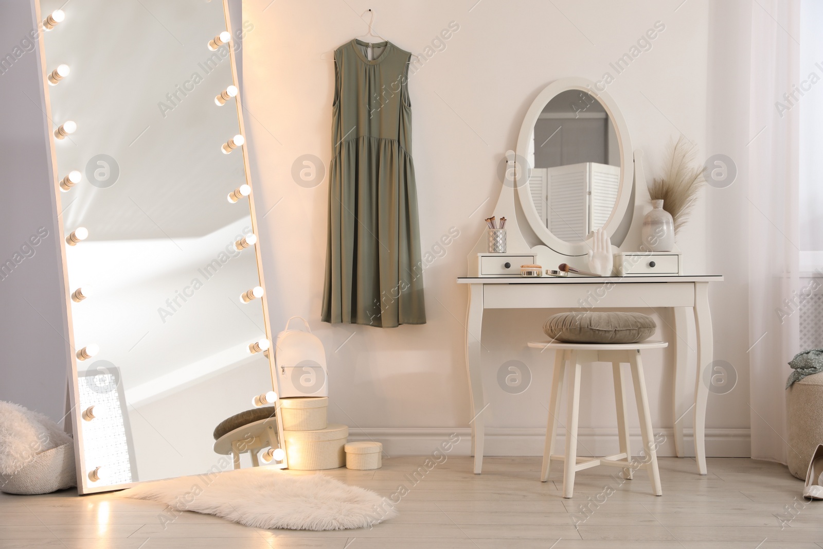 Photo of Large mirror with light bulbs and dressing table in stylish room. Interior design