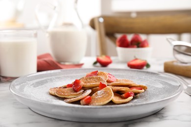 Delicious mini pancakes cereal with strawberries served on white marble table