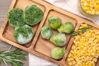 Tray with different frozen vegetables on wooden table, top view