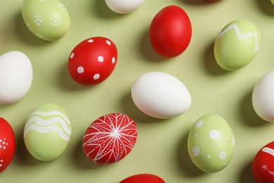 Photo of Flat lay composition of painted Easter eggs on color background