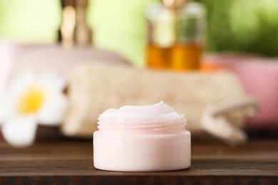 Photo of Jar of body care product on table against blurred background. Space for text