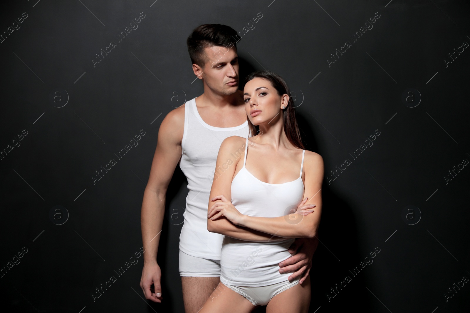 Photo of Young couple wearing underwear on black background