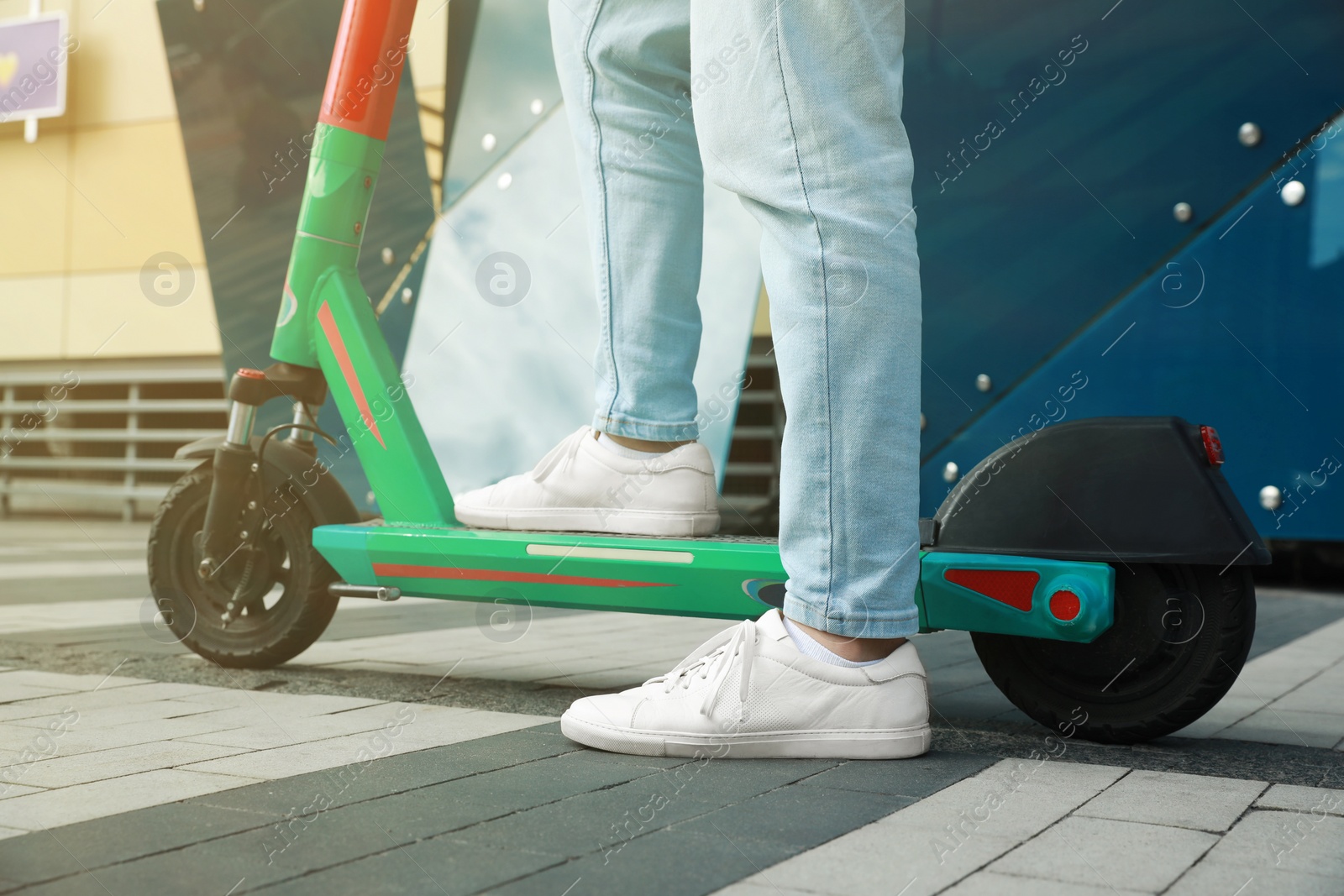 Photo of Man with modern electric kick scooter outdoors, closeup