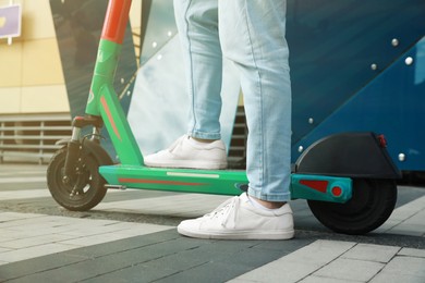 Photo of Man with modern electric kick scooter outdoors, closeup