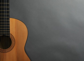 Photo of Beautiful classical guitar on gray background, top view with space for text. Musical instrument