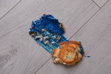 Photo of Dropped and smashed cupcake with cream on floor. Troubles happen