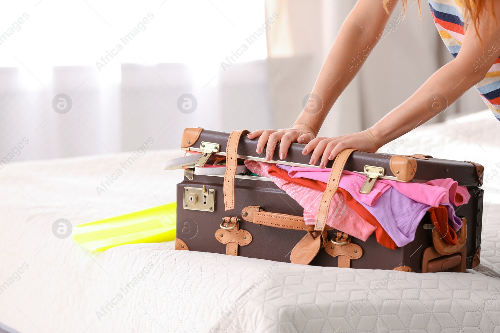 Photo of Woman packing suitcase for journey at home