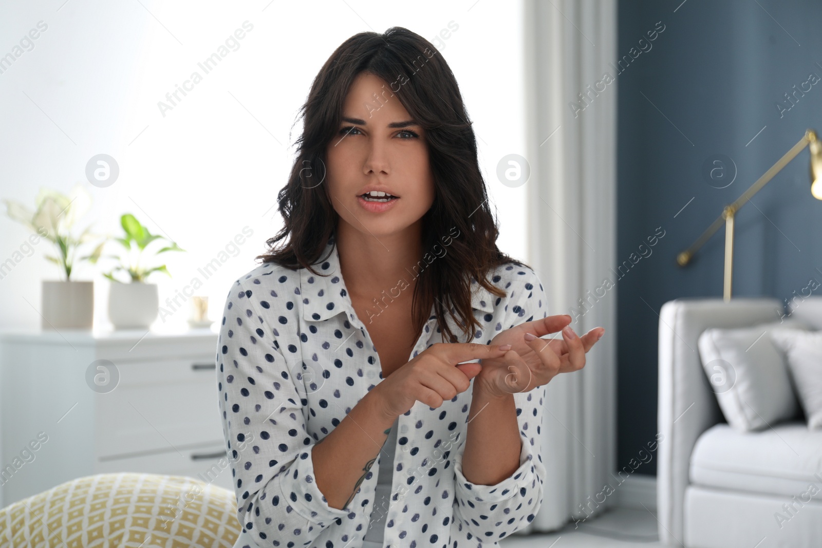 Photo of Young woman talking to her coworkers through video conference indoors, view from webcam