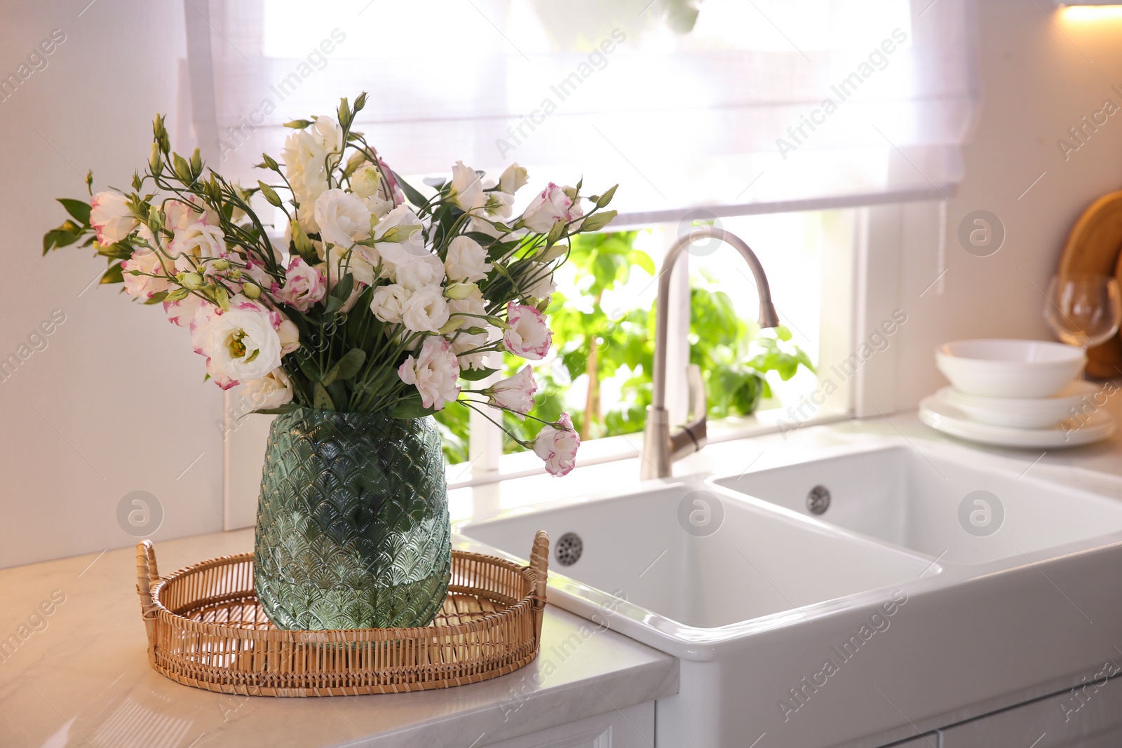 Photo of Bouquet of beautiful flowers on countertop in kitchen, space for text. Interior design