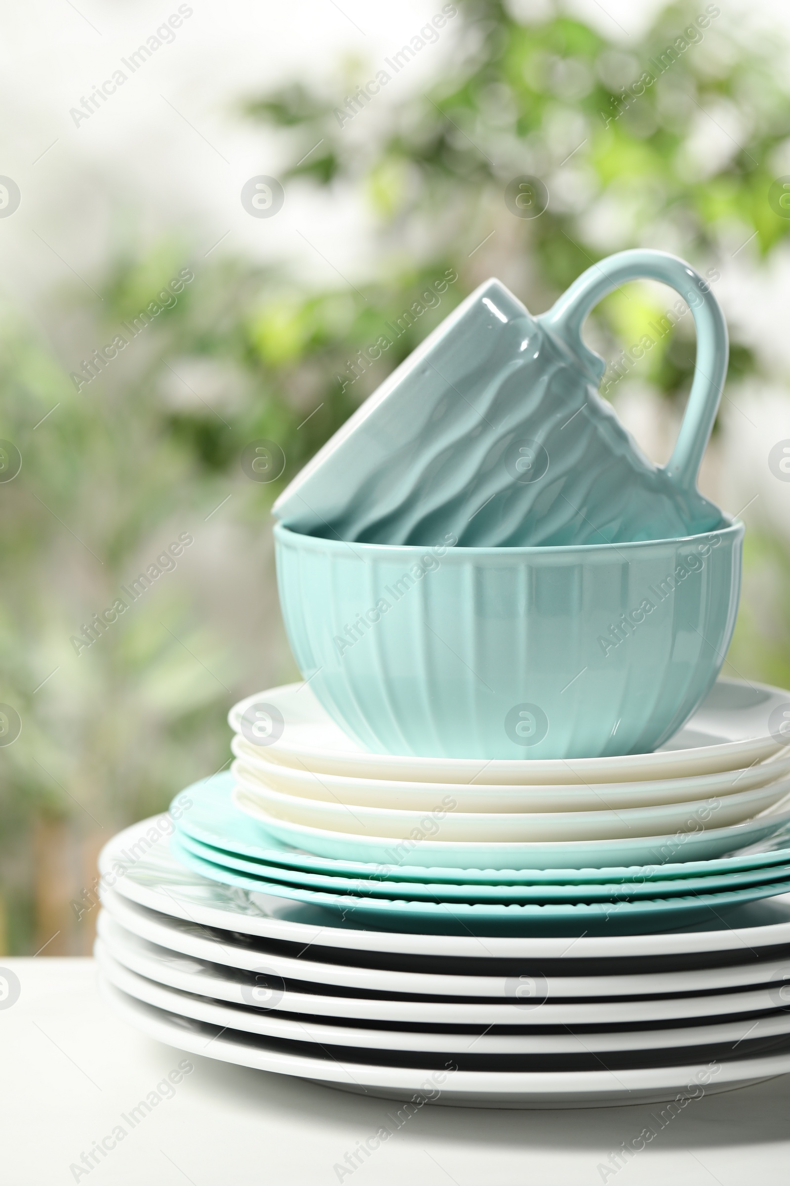 Photo of Beautiful ceramic dishware and cup on white table outdoors