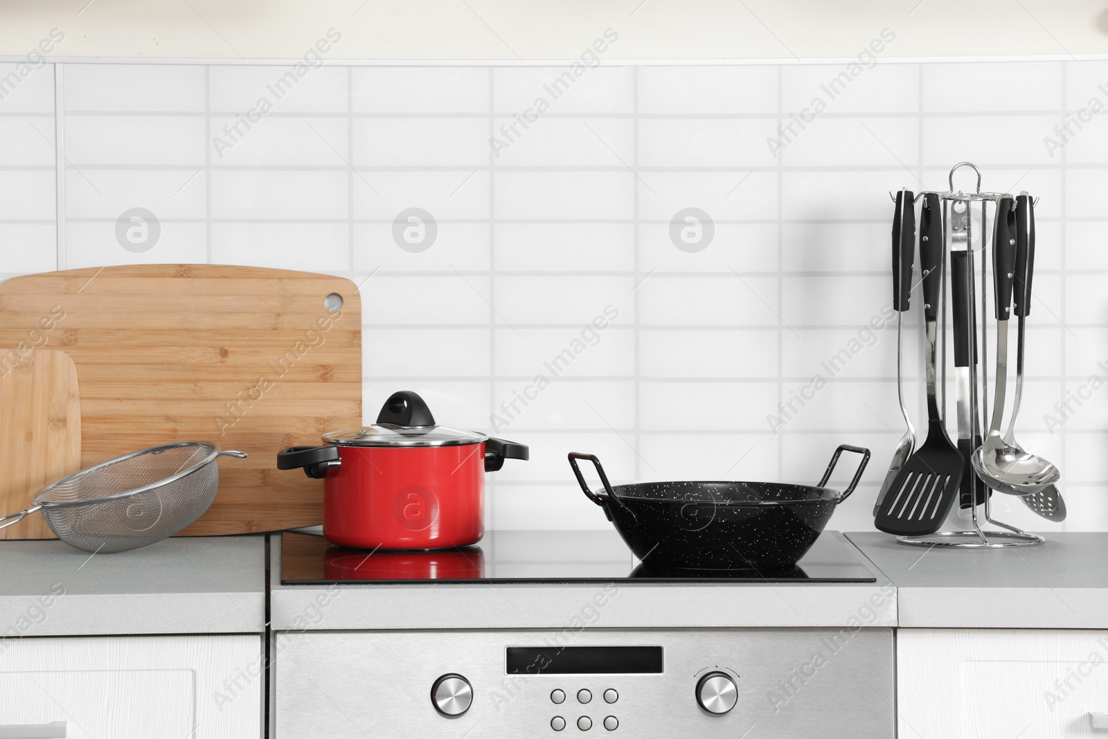 Photo of Clean cookware and utensils on table in kitchen