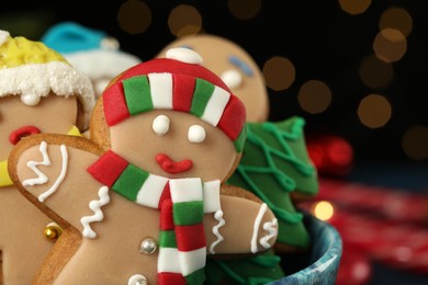 Photo of Delicious homemade Christmas cookies in bowl against blurred festive lights, closeup