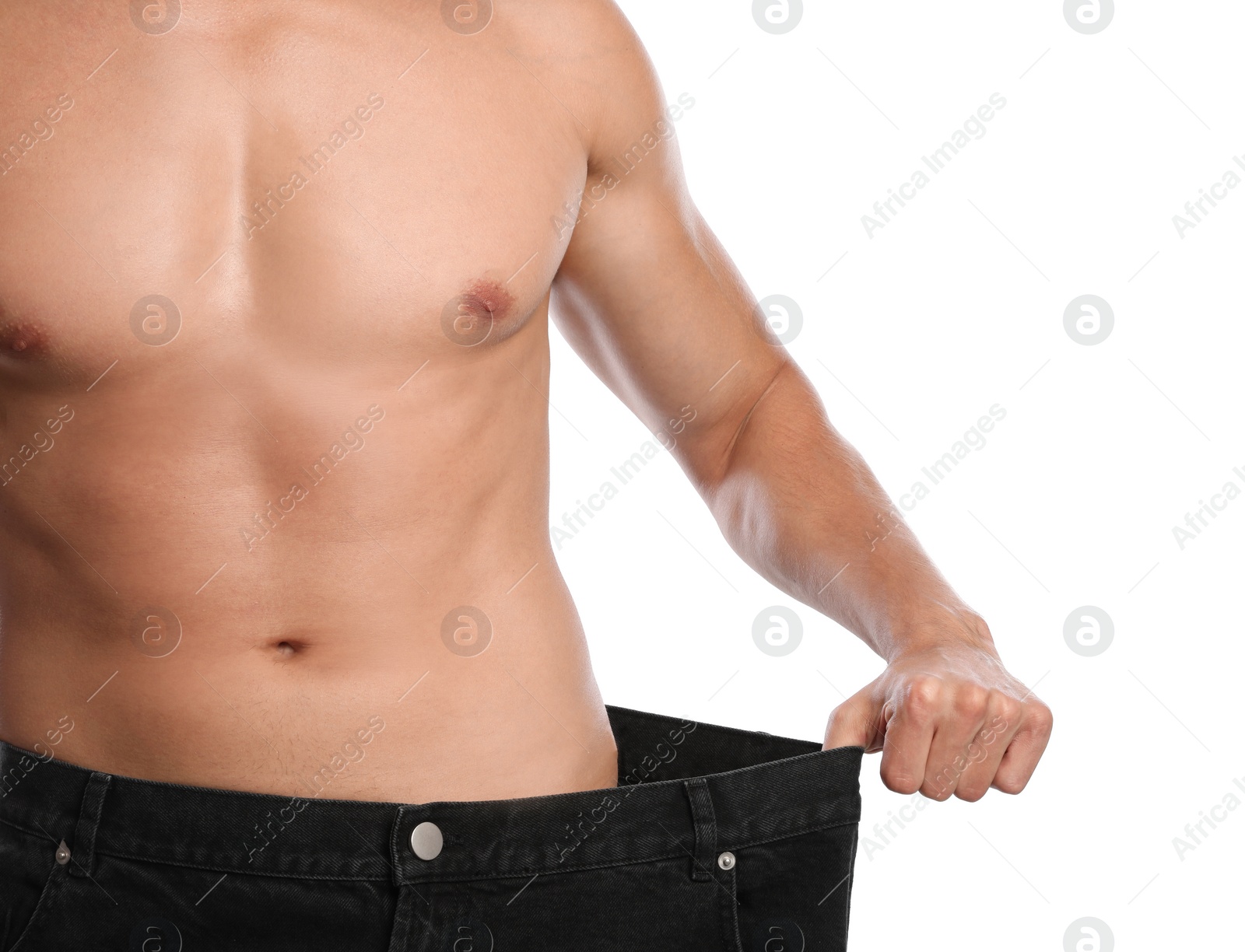 Photo of Young man with slim body in old big size jeans on white background, closeup view