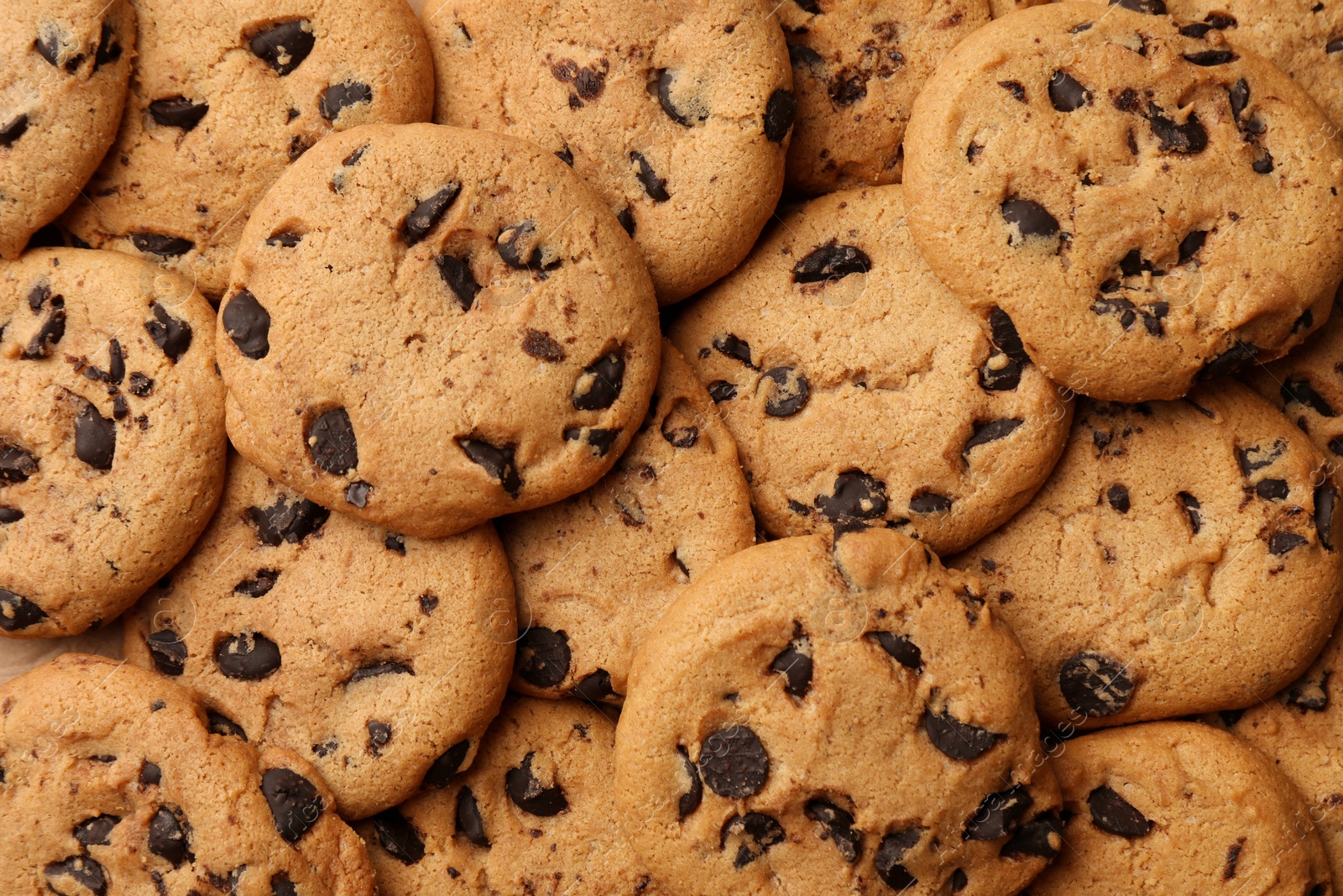 Photo of Delicious chocolate chip cookies as background, top view