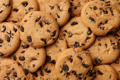 Delicious chocolate chip cookies as background, top view