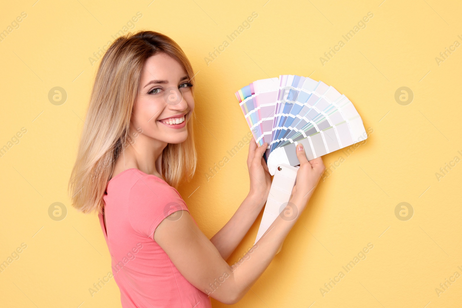 Photo of Young woman with color palette on yellow background