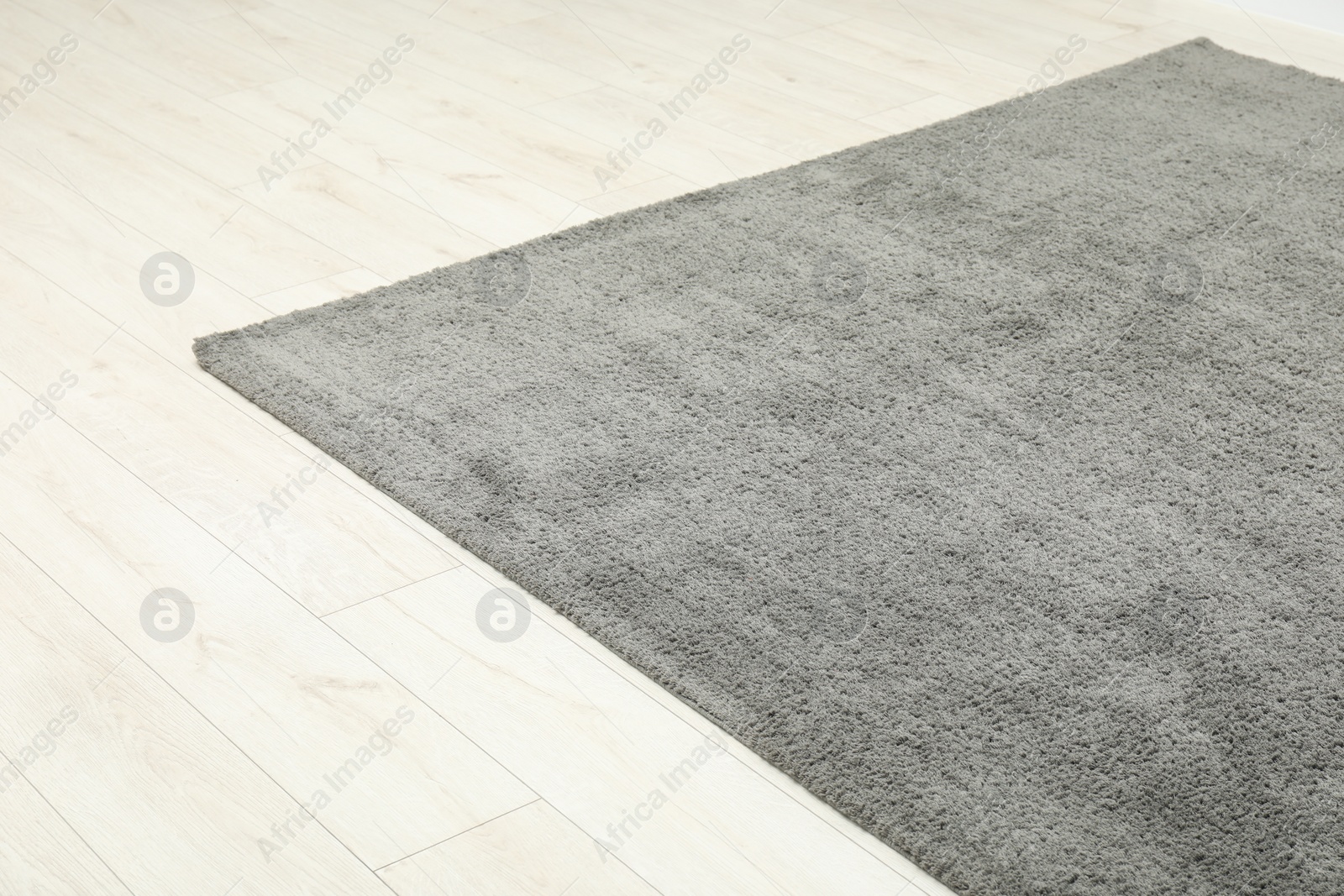 Photo of Soft grey carpet on white laminated floor indoors