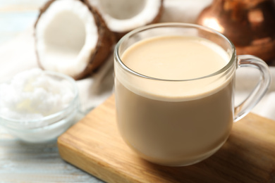 Photo of Delicious coffee with organic coconut oil on white wooden table