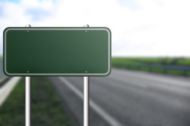 Blank green road sign on empty asphalt highway, space for text