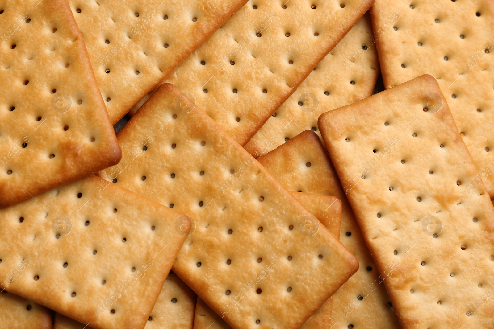 Photo of Many delicious crackers as background, top view