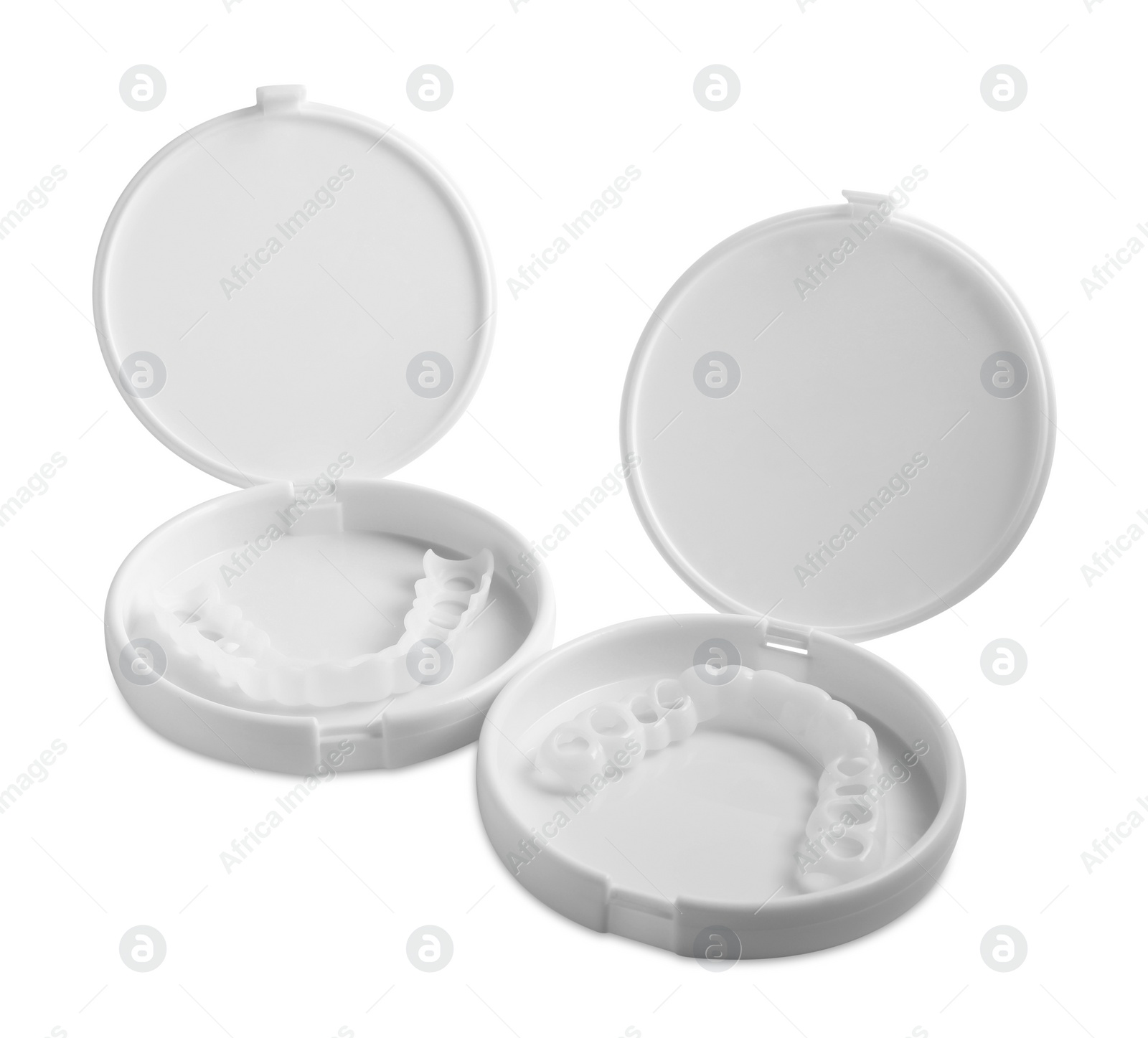 Photo of Containers with dental mouth guards on white background. Bite correction