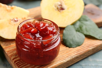 Photo of Delicious quince jam on light blue wooden table, closeup