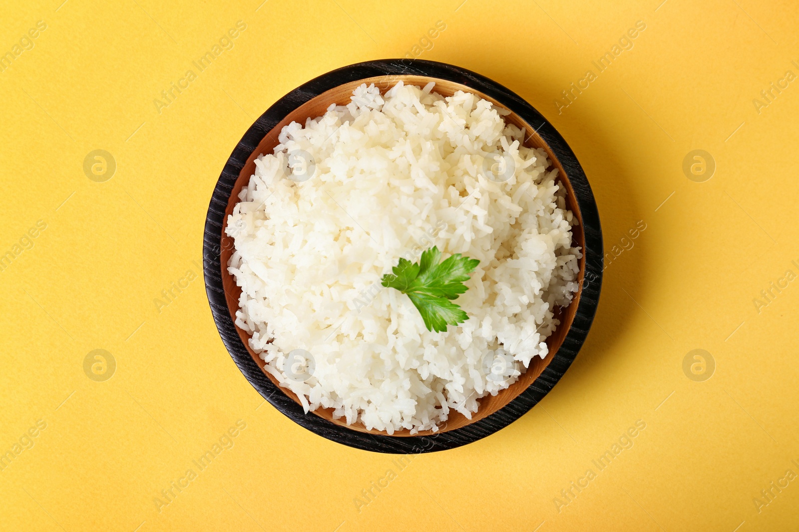 Photo of Bowl of boiled rice on color background, top view