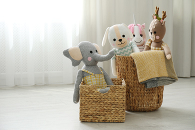 Photo of Funny stuffed toys in baskets on floor, space for text. Children's room interior decor