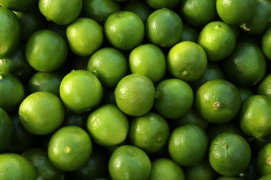 Fresh ripe green limes as background, top view