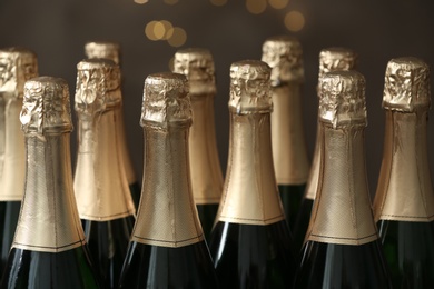 Many bottles of champagne on blurred background, closeup