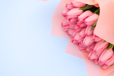 Photo of Bouquet of beautiful pink tulips on light grey background, above view. Space for text