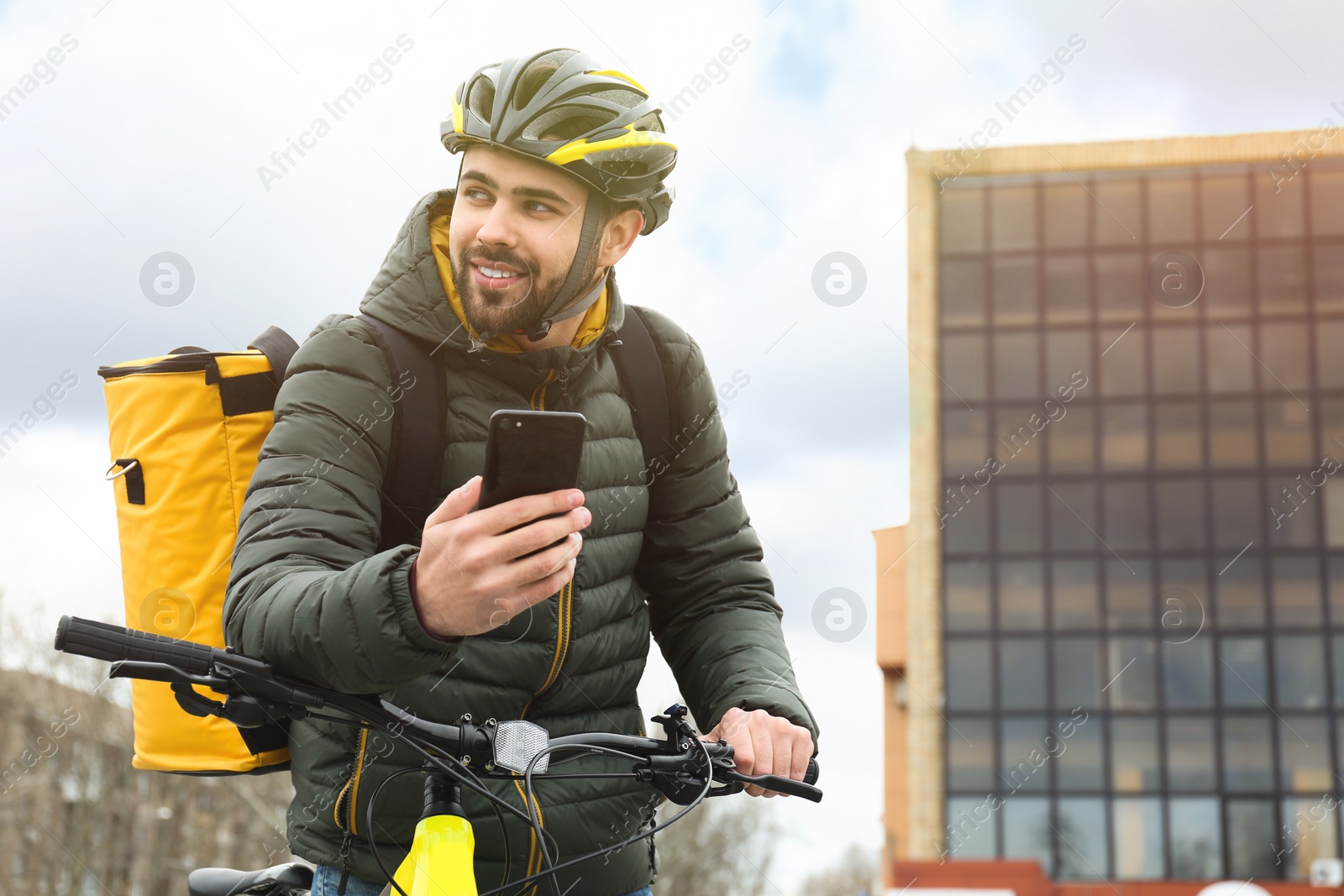 Photo of Courier with thermo bag and mobile phone on city street. Food delivery service