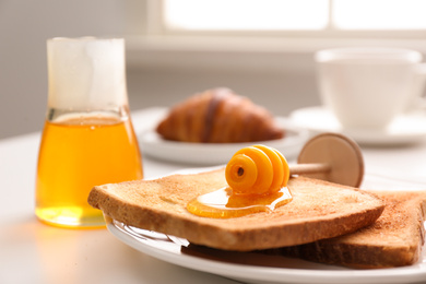Photo of Honey and toasts on white table, closeup