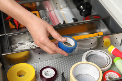Photo of Man taking adhesive tape from drawer indoors, closeup