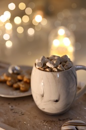 Cup of tasty hot drink and cookies on wooden table, space for text. Christmas atmosphere